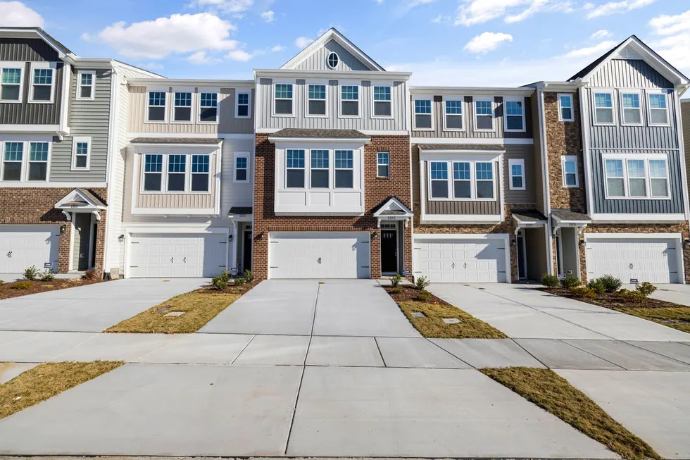 Row of new townhomes with garages and fresh driveways